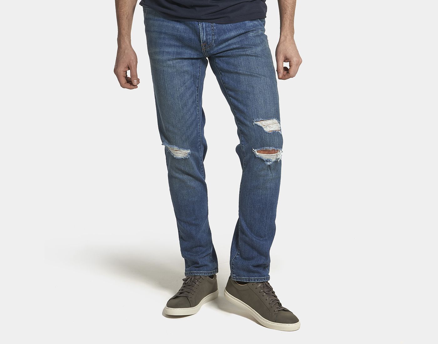 Custom distressed denim jeans with knee destruction and whiskering